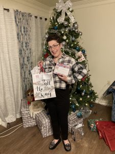 Brittany smiles with her gifts from the Share the Joy campaign.