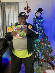 Joseph smiles with his gifts from the Share the Joy campaign.